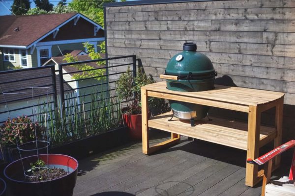 A big green egg smoker on specially suited big green egg table.