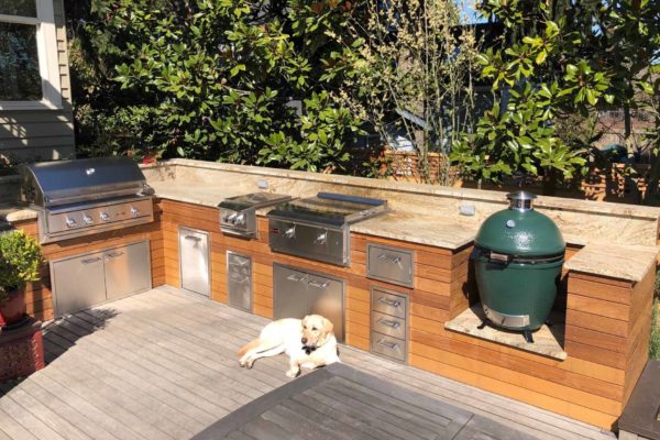 Outdoor kitchen with a grill and a big green egg smoker.