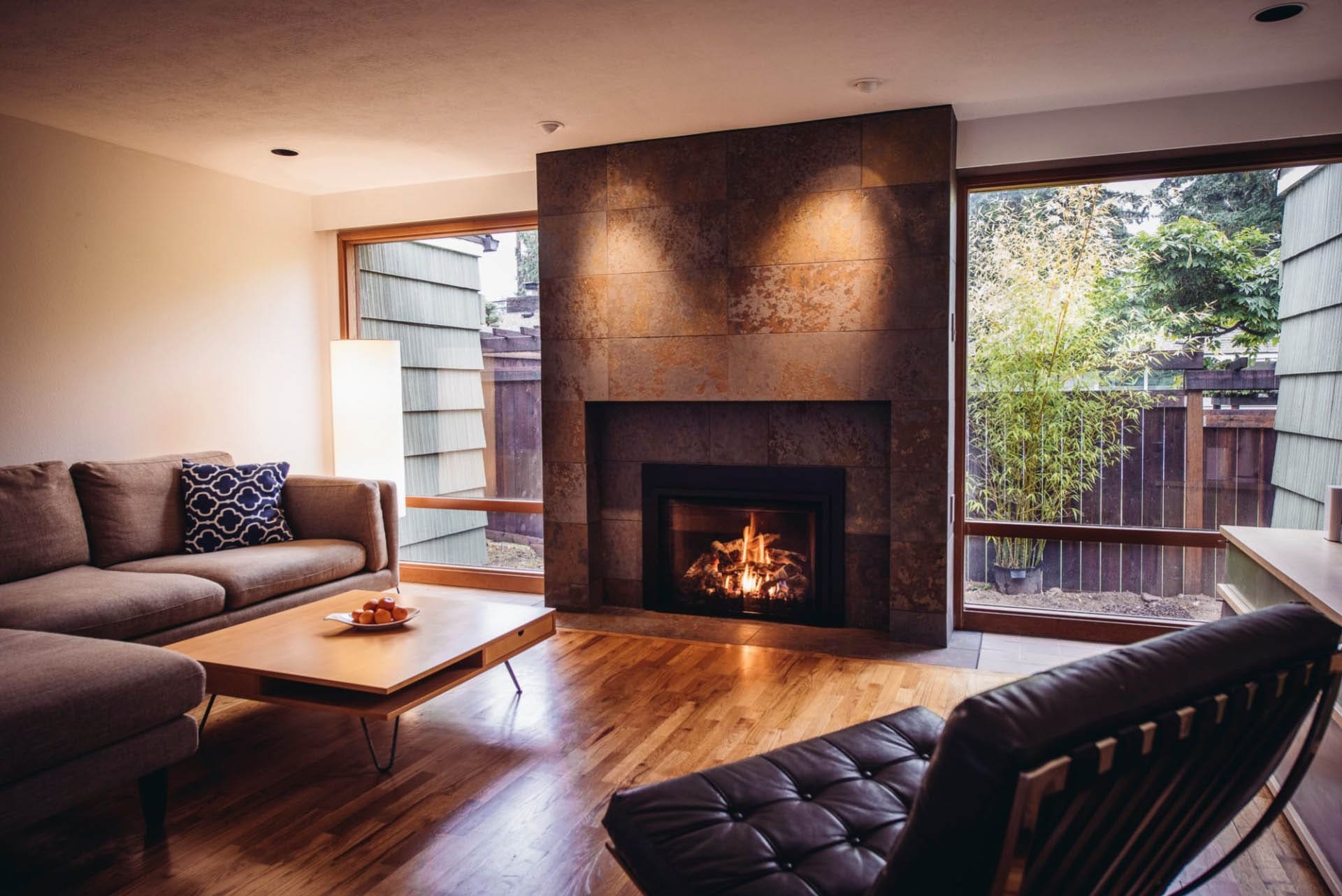 Minimalist living room featuring a large stone fireplace.