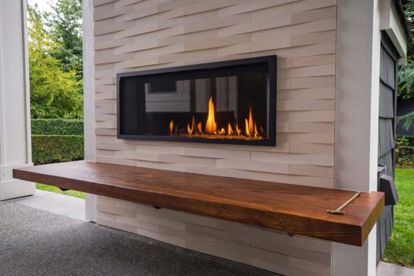 Outdoor fireplace with sleek wood bench.