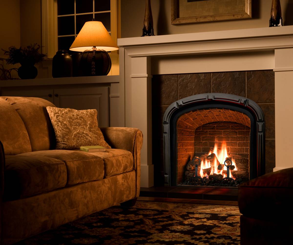 A cozy living room with a Mendota Greenbriar Gas Fireplace and a comfortable couch.