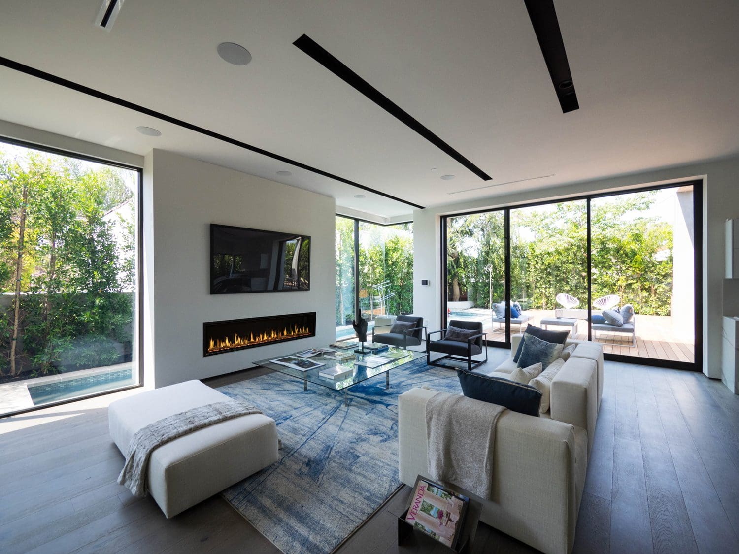 The Modern Flames Orion Slim Electric fireplace in a modern living room with a garden view