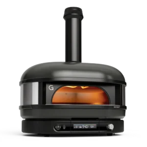 The Gozney Dome (Gen 2) is a sleek black outdoor pizza oven featuring a chimney, rounded top, and digital control panel. Its open door reveals an inviting orange glow from the heat inside.